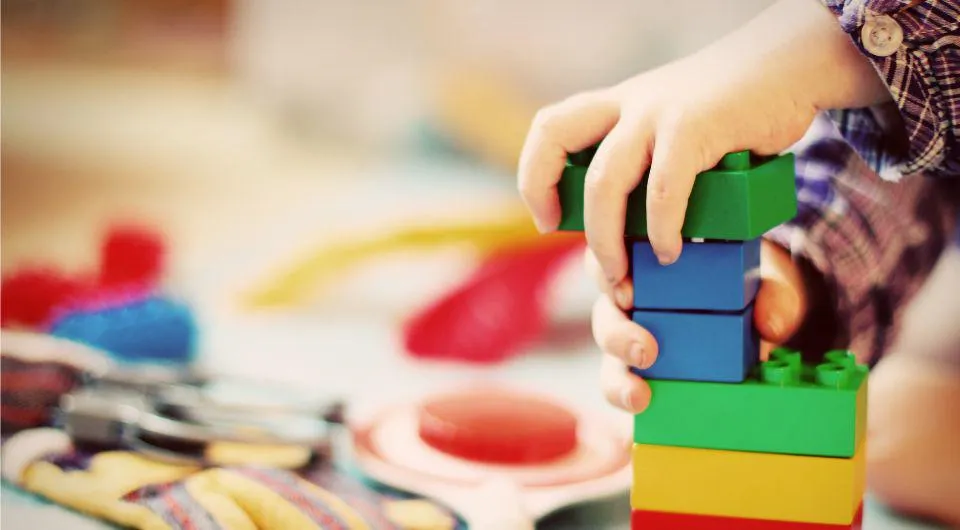 A child's hands playing with building blocks