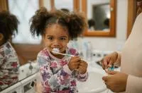 Image shows child brushing teeth