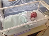 Newbor baby in a hospital cot