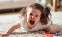 Girl lying on a rug having a tantrum