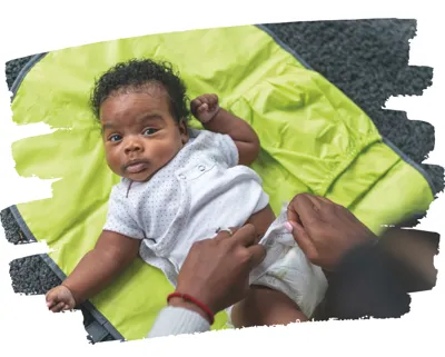 Baby on changing mat having its nappy changed
