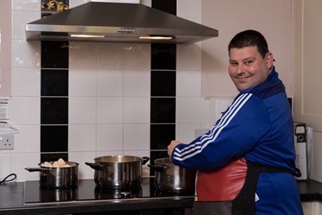 Young adult cooking living independently 