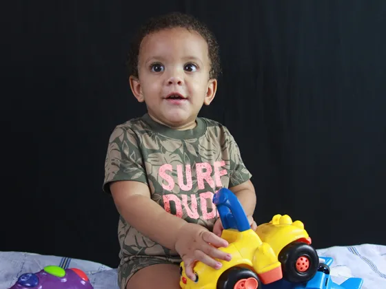 Toddler sat down with a yellow car toy