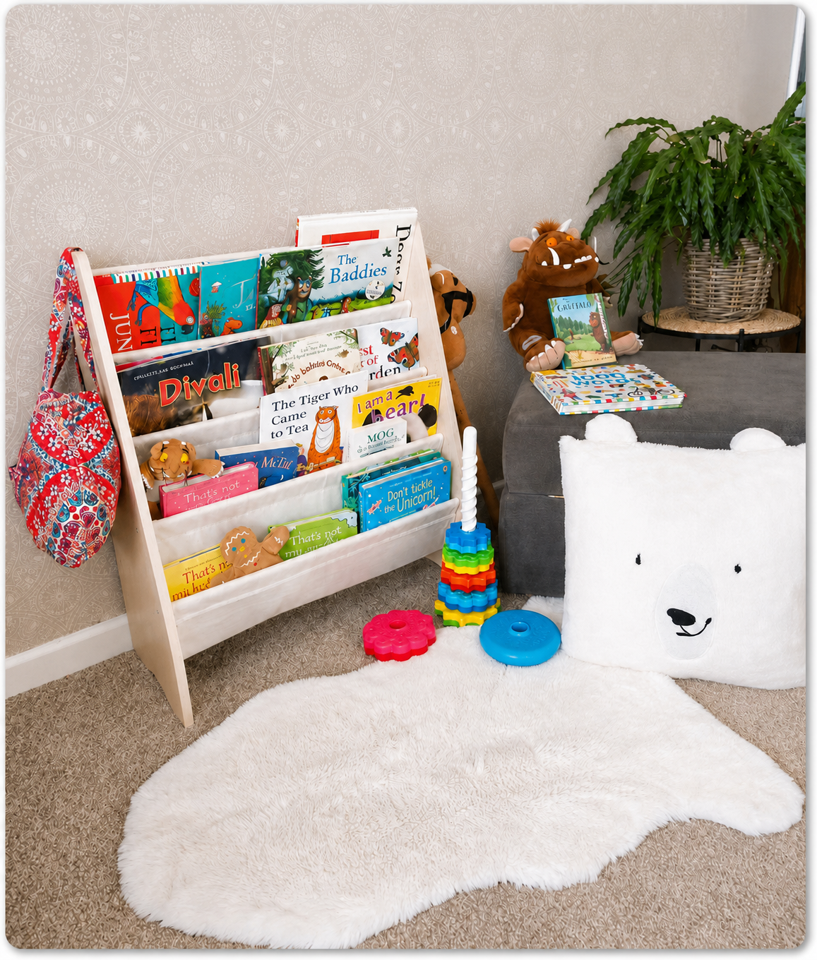 Children’s reading corner with a bookshelf, rug, and toys on the floor.