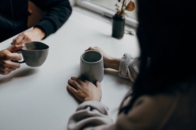 Two people sitting at table with coffee