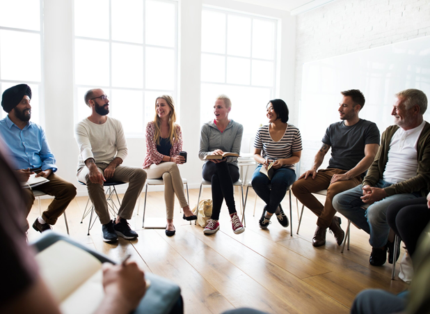 Group of people sitting in a circle on chairs