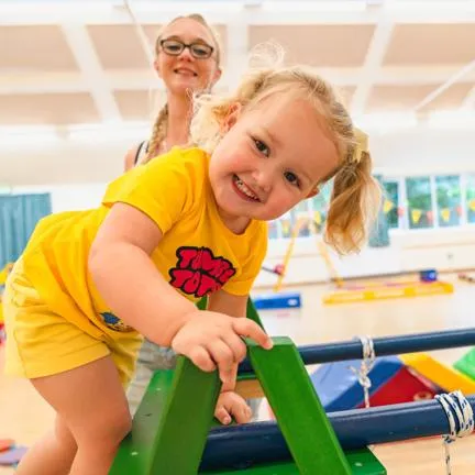 Girl on a wooden climbing frame