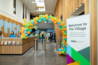 YMCA inside. Brightly coloured balloons create an archway.