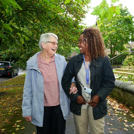 Live-in carer walking with elderly lady