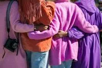 People with arms around each others waists