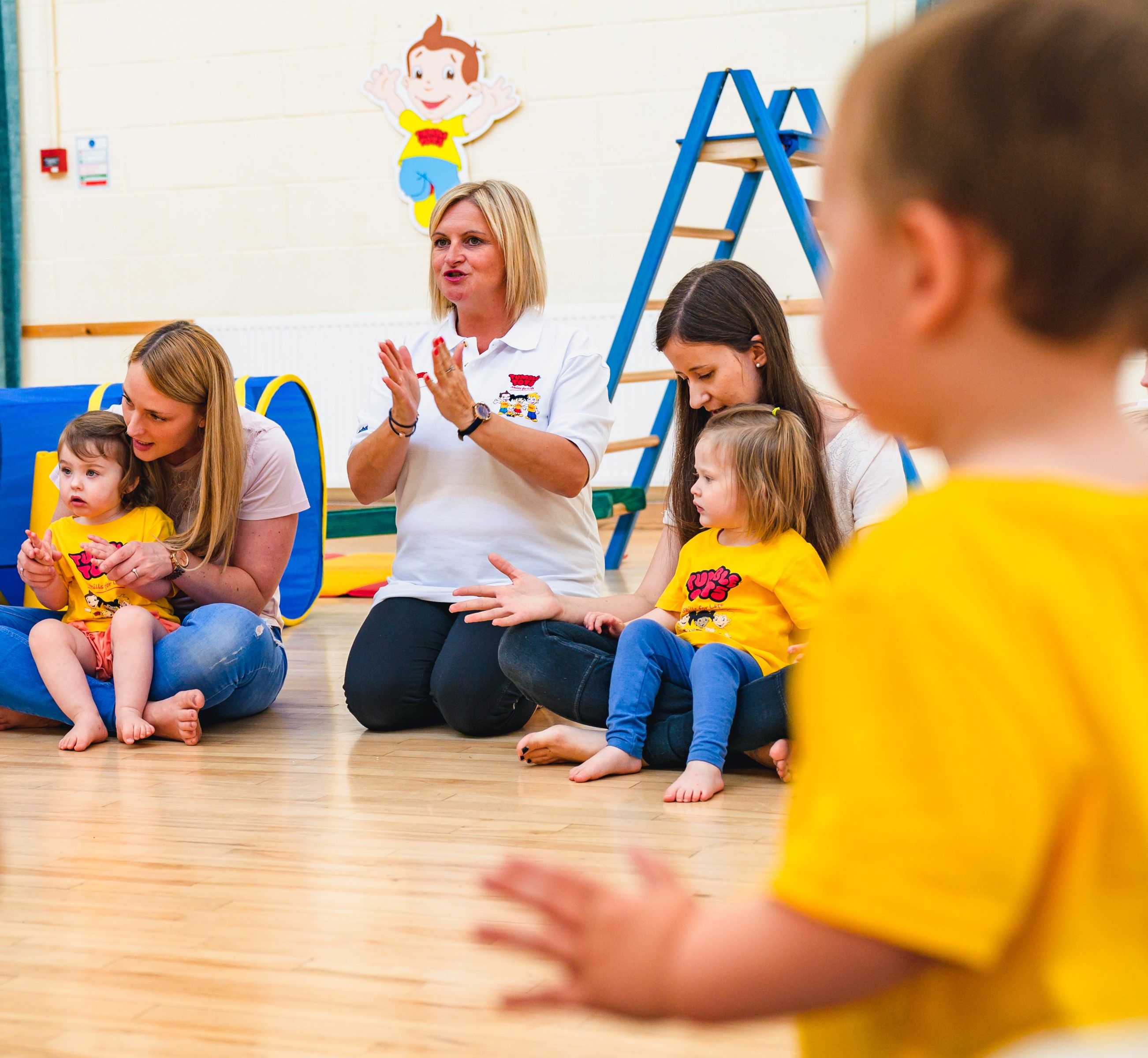 Parents and children sat in a circle singing and clapping