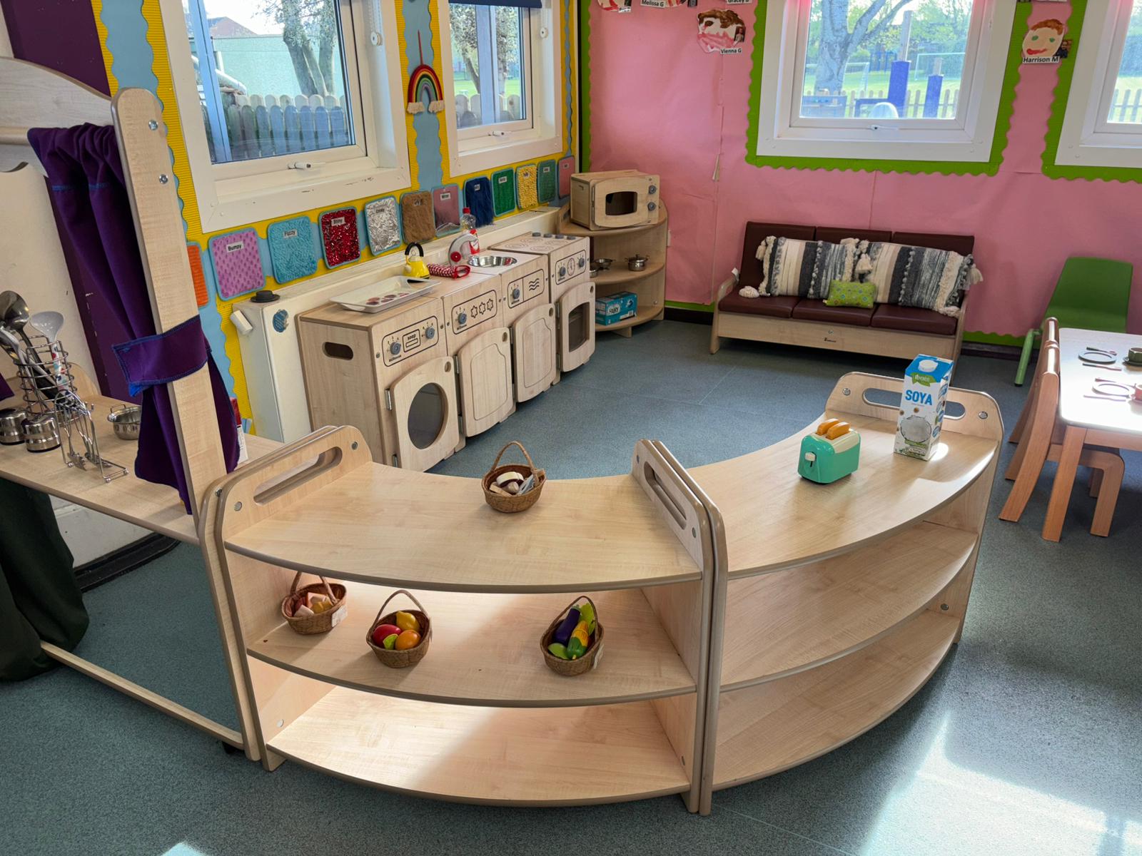 A natural wood shelving for children home corner set up with play kitchen area