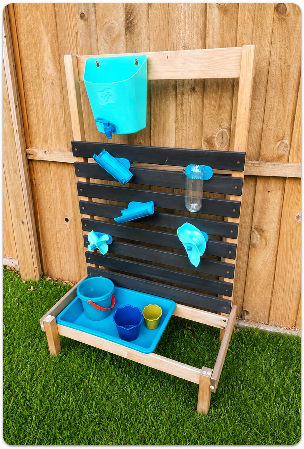 Wooden outdoor water play station with blue buckets, funnels, and cups attached