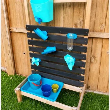 Wooden outdoor water play station with blue buckets, funnels, and cups attached